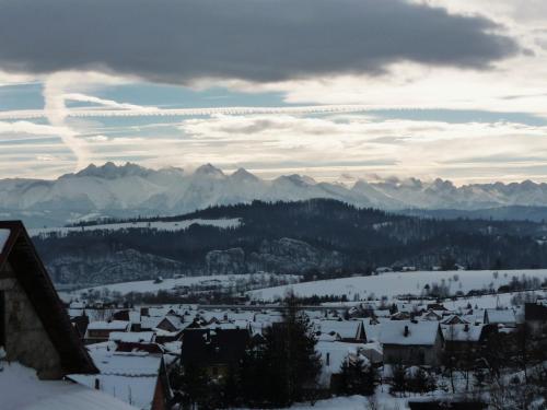 a view of a town in the snow with mountains at Dom Sosenek in Kluszkowce