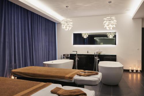 a bedroom with two beds and a tub and a mirror at Rezydencja Nosalowy Dwór in Zakopane