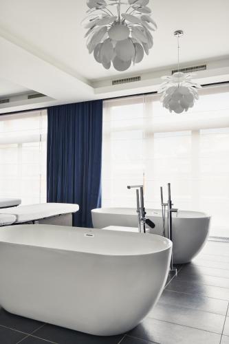 a bathroom with two sinks and a tub and two toilets at Rezydencja Nosalowy Dwór in Zakopane