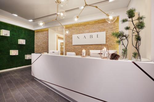 a lobby with a white reception counter and a brick wall at Rezydencja Nosalowy Dwór in Zakopane