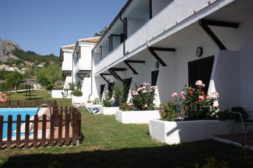 a house with a fence and flowers in a yard at Villa Turística de Grazalema in Grazalema