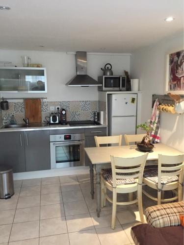 - une cuisine avec une table, une table et des chaises dans l'établissement Maison de pêcheur 30m de la plage, à Luc-sur-Mer