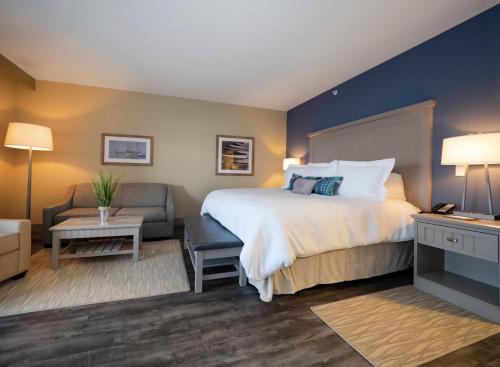 a hotel room with a large bed and a chair at Chautauqua Harbor Hotel - Jamestown in Celoron