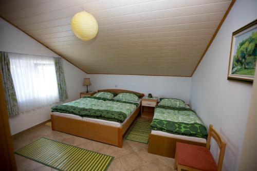Apartment Sandra FREE PRIVATE PARKING في دوبروفنيك: سريرين في غرفة صغيرة مع ملاءات خضراء