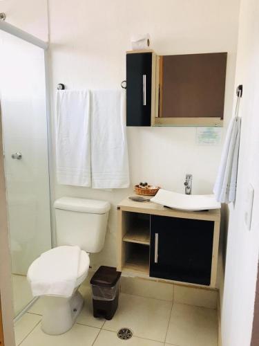 a bathroom with a toilet and a sink at Don Marcos Hotel com Restaurante e Pizzaria in Guarujá