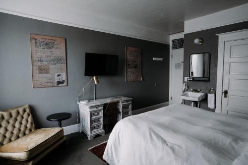 a bedroom with a bed and a television and a sink at Hood River Hotel in Hood River