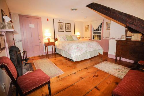 a bedroom with a bed and a table and a chair at The Nutmeg Inn in Meredith