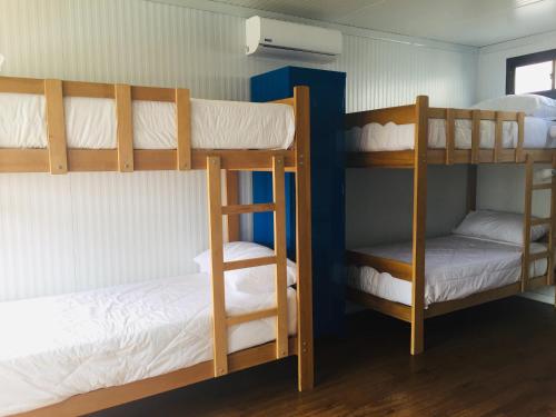 two bunk beds in a room with white sheets at Surfari Punta Rocas in Punta Negra