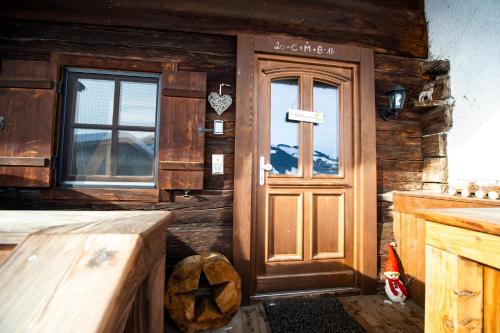 a wooden cabin with a door and a window at Hof Hintererb in Kitzbühel