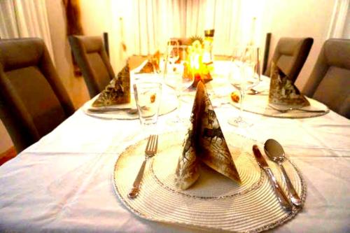 stół z talerzami i przyborami kuchennymi na białej ścierce stołowej w obiekcie Family Apartment Alpine Living 2-4 Persons w mieście Radstadt