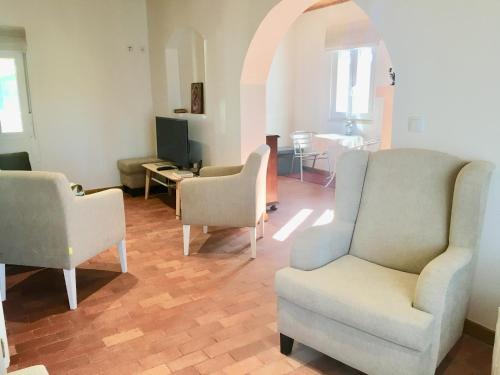 a living room with two chairs and a table at Casa do Chaparral campo e praia in Cercal