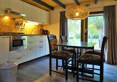 a kitchen with a table and chairs in a kitchen at De Oude Stoffeerderij in Dussen