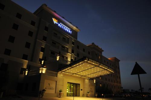 a hotel with a sign on top of it at night at Metcourt at Emperors Palace in Kempton Park