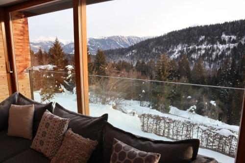 a couch in front of a large window with a view at Casa Fluras in Flims