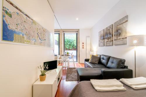 a living room with a couch and a map on the wall at Merc Porto Clérigo's Place in Porto