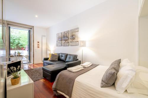 a living room with a bed and a couch at Merc Porto Clérigo's Place in Porto
