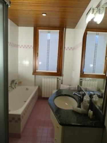 a bathroom with a sink and a bath tub and a tub at La casa di Clara in Esine