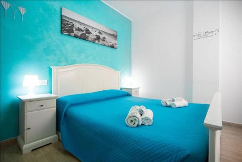 ベシンダリオにあるCanary House Goldの青いベッドルーム(タオル付きのベッド付)