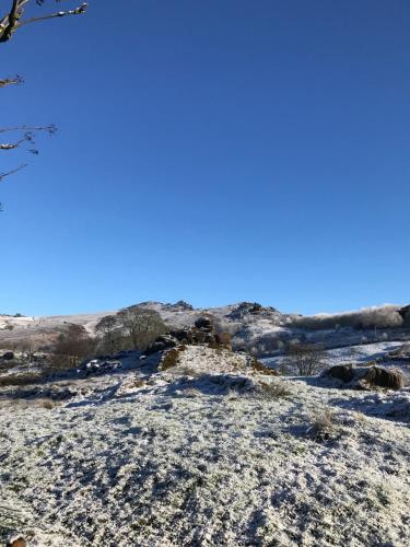 a snow covered hill with a blue sky in the background at The Laburnum Retreat Shepherd Hut private hot Tub in Upper Hulme