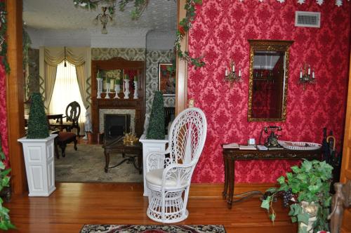 a living room with pink walls and a white chair at Queen Anne Bed and Breakfast in Nevada