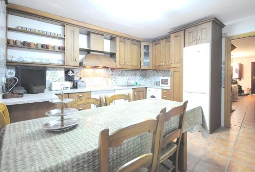 eine Küche mit einem Tisch mit Stühlen und einem Kühlschrank in der Unterkunft CASA JOTA in Lerma