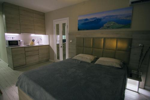 a bedroom with a large bed and a kitchen at Swiss Quality Apartments (Beach Tower) in Batumi