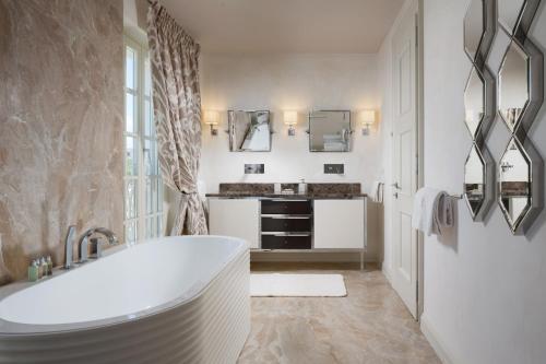 a white bathroom with a tub and a sink at Villa Hermitage in Vabriga