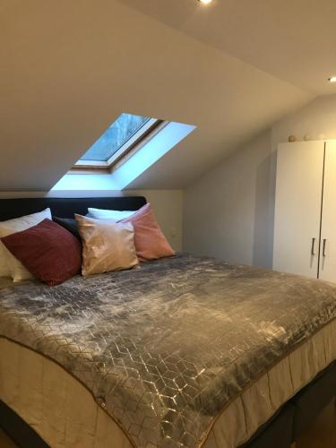 a bedroom with a large bed with a skylight at Le saxo cuivré in Dinant