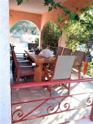 a wooden table and chairs on a patio at Villa Ioanneta in Achladi