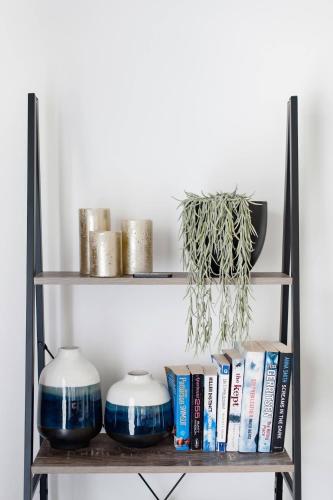 a shelf with two blue and white vases and books at Cyprus Place in Melton