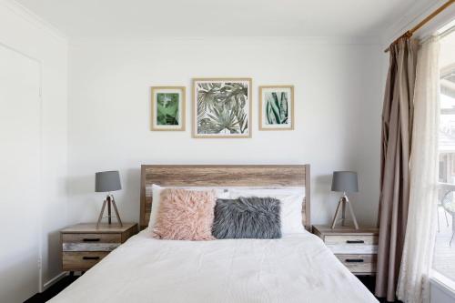 a bedroom with a white bed with two night stands at Cyprus Place in Melton