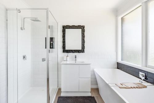 La salle de bains blanche est pourvue d'une baignoire et d'un lavabo. dans l'établissement Cyprus Place, à Melton
