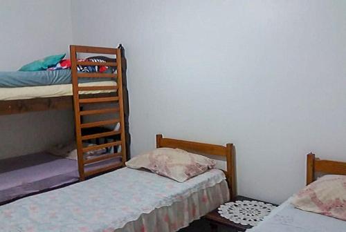 een kamer met 2 stapelbedden en een ladder bij Casa Praia Arpoador in Peruíbe