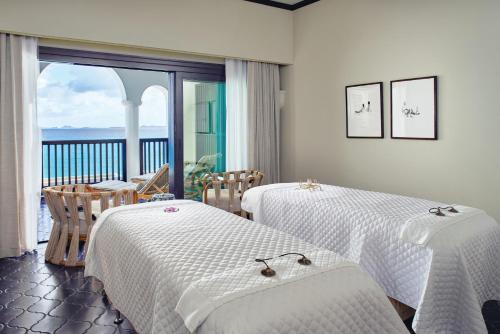 a hotel room with two beds and a balcony at Cap Juluca, A Belmond Hotel, Anguilla in West End Village