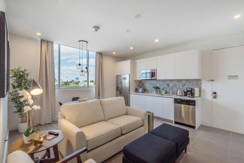a living room with a couch and a kitchen at VHC Modern Apartments in Miami Beach