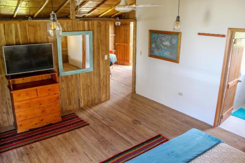 una sala de estar con TV en un tocador de madera en Cuna Luna Hosteria, en Olón