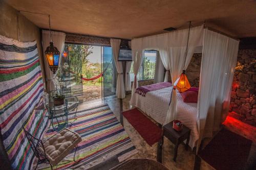 a bedroom with a canopy bed and a window at Villa Buena Vista in Praia do Rosa