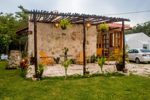 a backyard with a pergola and a house at Aldea Isla Sagrada in Cozumel