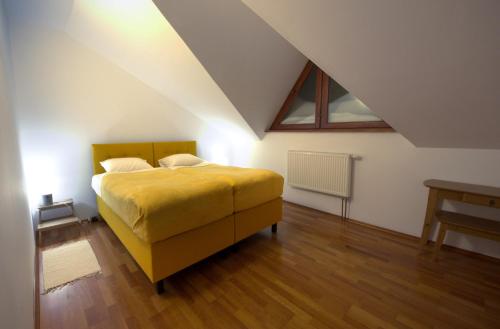 a bedroom with a yellow bed in a attic at Dom Przy Lesie in Wisła