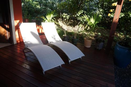 two white chairs sitting on a wooden deck at Caraibe Créol' Keys in Port-Louis