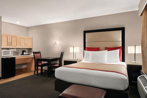 a hotel room with a large bed and a desk at Hawthorn Suites by Wyndham Lancaster in Lancaster