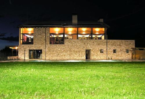 a large brick building at night with a green field at Hotel Rural y SPA Kinedomus Bienestar in Aranda de Duero