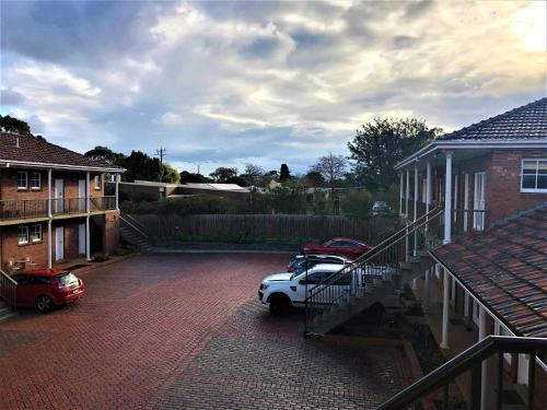 a car parked in a driveway next to a house at Glen Inn in Glen Waverley