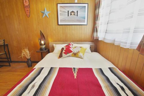 a bedroom with a bed with a red rug at Villent Kujukuri Arrow in Kujukuri