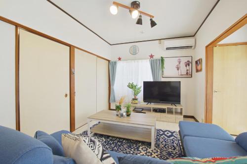 a living room with a blue couch and a tv at Villent Kujukuri Arrow in Kujukuri
