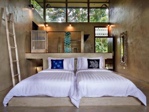 1 dormitorio con 1 cama grande en una habitación con ventanas en Gunung An Retreat en Ubud