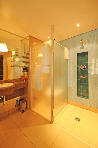 a bathroom with a shower and a sink at Metcourt at Emperors Palace in Kempton Park