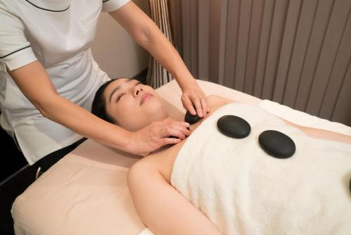 a woman getting a back massage in a bath tub at Resort Kumano Club in Kumano