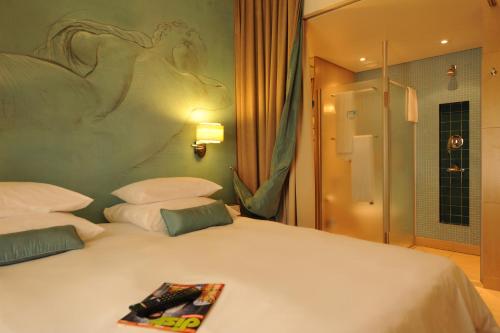 a bedroom with a white bed with a book on it at Metcourt at Emperors Palace in Kempton Park