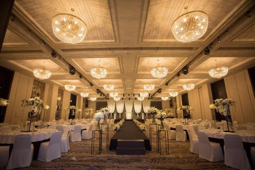 a banquet hall with white tables and chairs and chandeliers at Stanford Hotel&Resort Tongyeong in Tongyeong